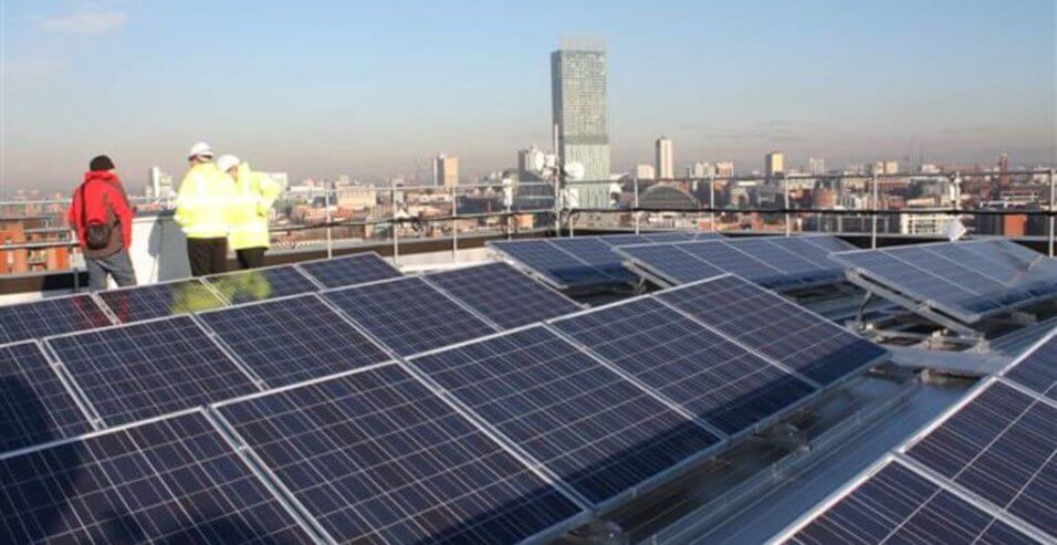 people in hi viz on roof with solar panels installed